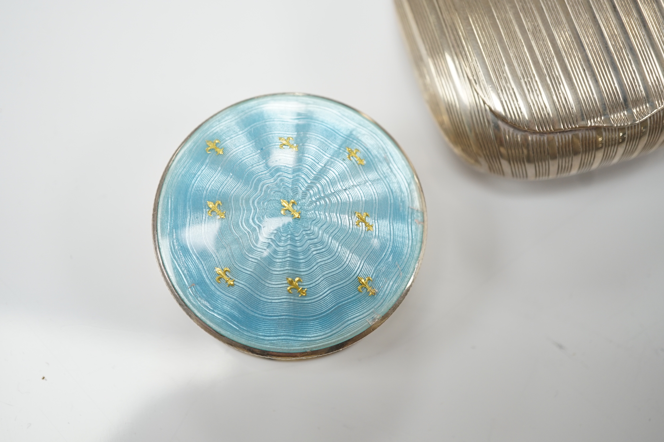 A George V silver and enamelled circular pill box and cover, Birmingham, 1910, 48mm and a German 900 standard white metal tobacco? box.